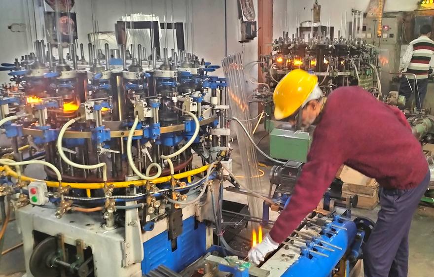 Worker operating the ampoule forming machine on our Sirsa factory floor